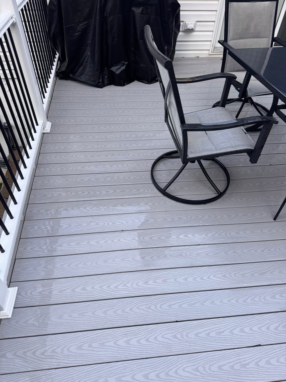 A grey composite deck with patio furniture, cleaned