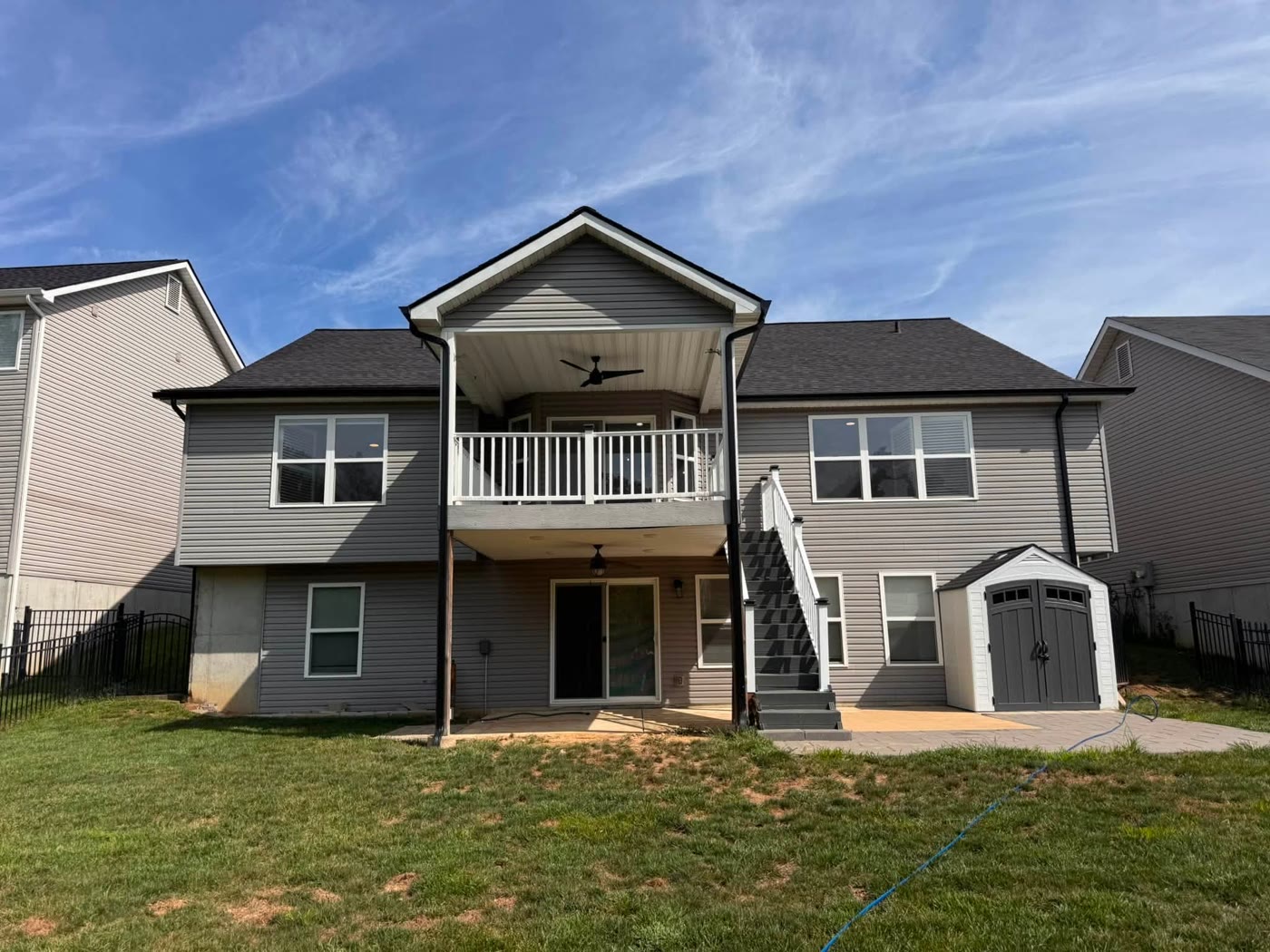 A large grey two-storey home with a clean exterior and deck